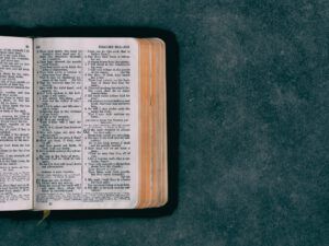 Open Bible laid flat on a dark textured surface, evoking Why Reading the Bible When Sleepy is the Key to Spiritual Growth.