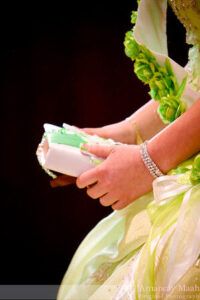 Persona con vestido verde y pulsera sosteniendo un libro pequeño blanco con la pregunta ¿En qué año se escribió la Biblia Reina Valera 1960?