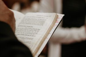 Mano sosteniendo un libro religioso abierto con anotaciones, ¿Qué dice la Biblia sobre abandonar a los hijos? Descubre la verdad aquí