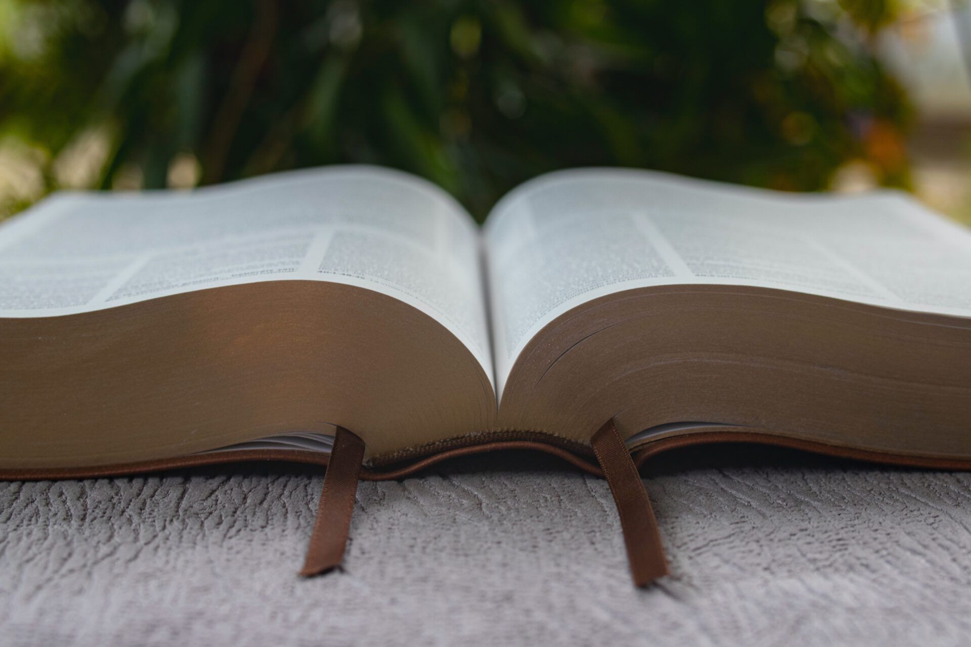 Biblia abierta con dos marcapáginas sobre una superficie texturizada, perfecta para meditar: ¿Qué dice la Biblia sobre juzgar a los demás?