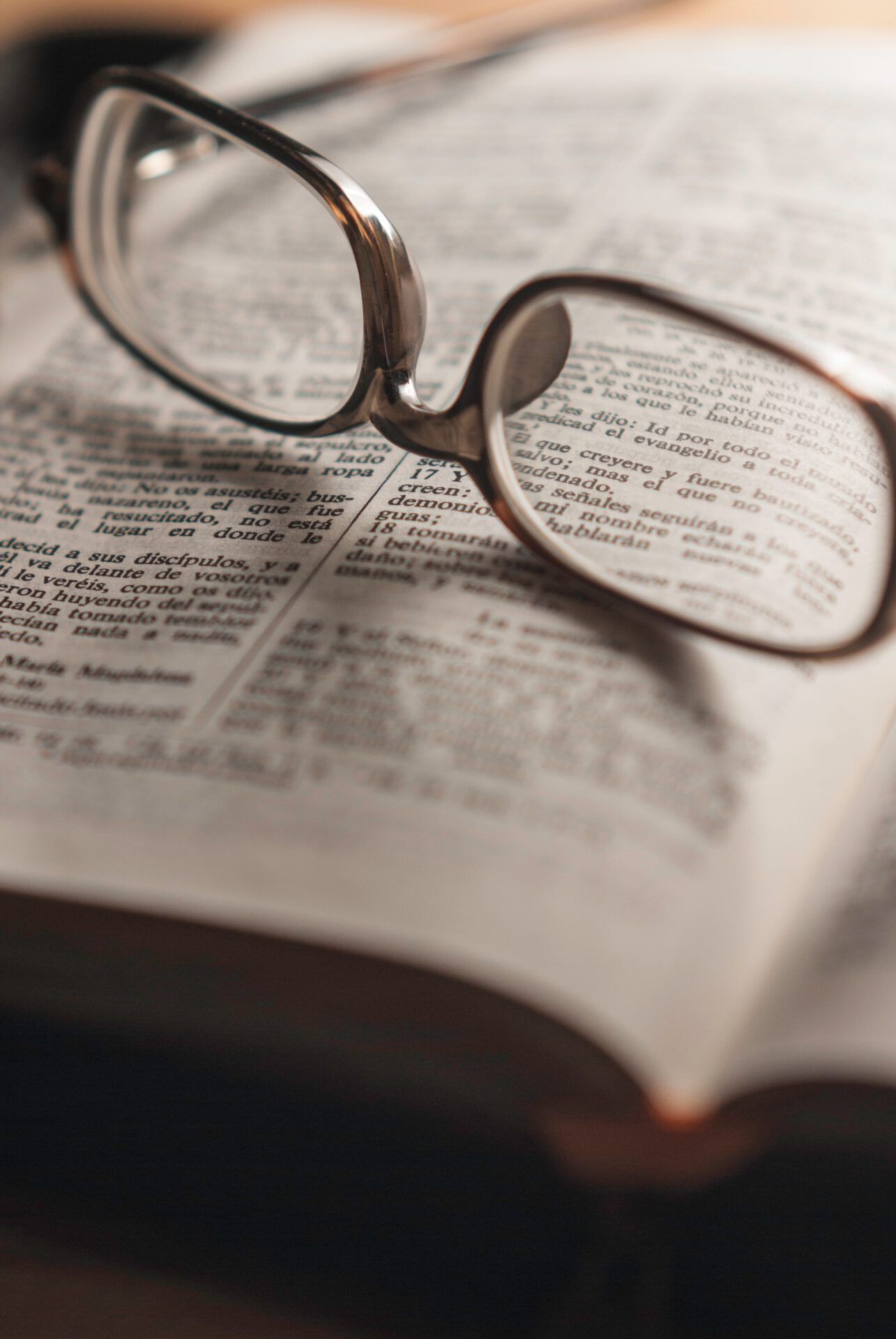 Gafas sobre una Biblia abierta en primer plano, ¿Qué enseña la Biblia sobre el miedo? Descubre sus respuestas aquí.
