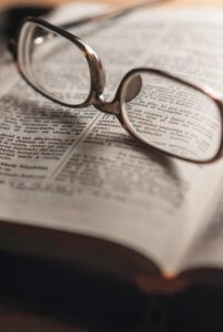 Gafas sobre la Biblia abierta en primer plano; ¿Sabías que la Biblia niega la existencia del 30 de febrero?