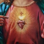 Descubre el Origen del Sagrado Corazón de Jesús para Niños mostrando un corazón flameante con corona de espinas, cruz y manos señalando el pecho