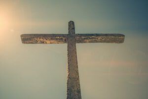 Cruz de piedra elevada contra un cielo luminoso al amanecer, evocando la pregunta: ¿Qué enseña la Biblia sobre ganar almas?