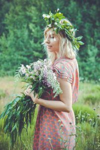 Mujer joven con corona de flores y ramo silvestre en un prado contemplando la naturaleza, ¿Quiénes son los gentiles mencionados en la Biblia y por qué son importantes?