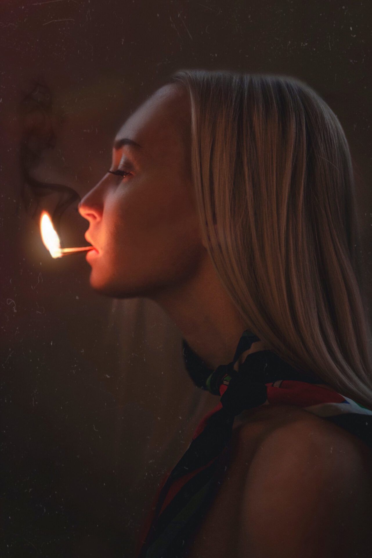 Perfil de mujer sosteniendo una cerilla encendida entre los labios y humo tenue; ¿Es bíblico orar por los muertos? Descubre lo que dice la Biblia