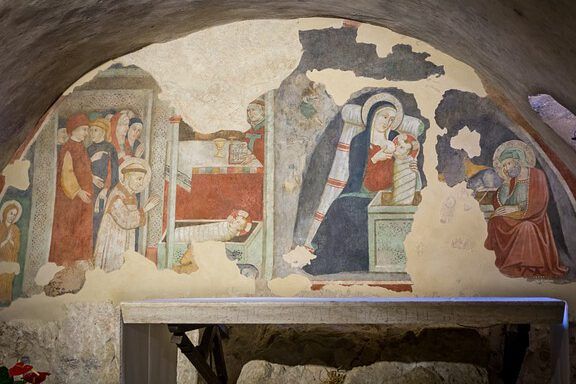 La verdad sobre la pobreza según la Biblia: ¿Qué enseña realmente? Fresco medieval en una bóveda que muestra una escena de nacimiento con la Virgen sosteniendo al niño, figuras acompañantes y signos de humildad y caridad.