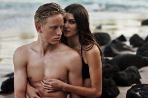 Pareja abrazada junto a las rocas en la playa, ¿Qué dice la Biblia sobre vivir en unión libre?