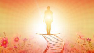 ¿Qué enseña la Biblia sobre la muerte y la vida después de ella? Silueta humana ascendiendo por un camino iluminado entre flores hacia una luz dorada.
